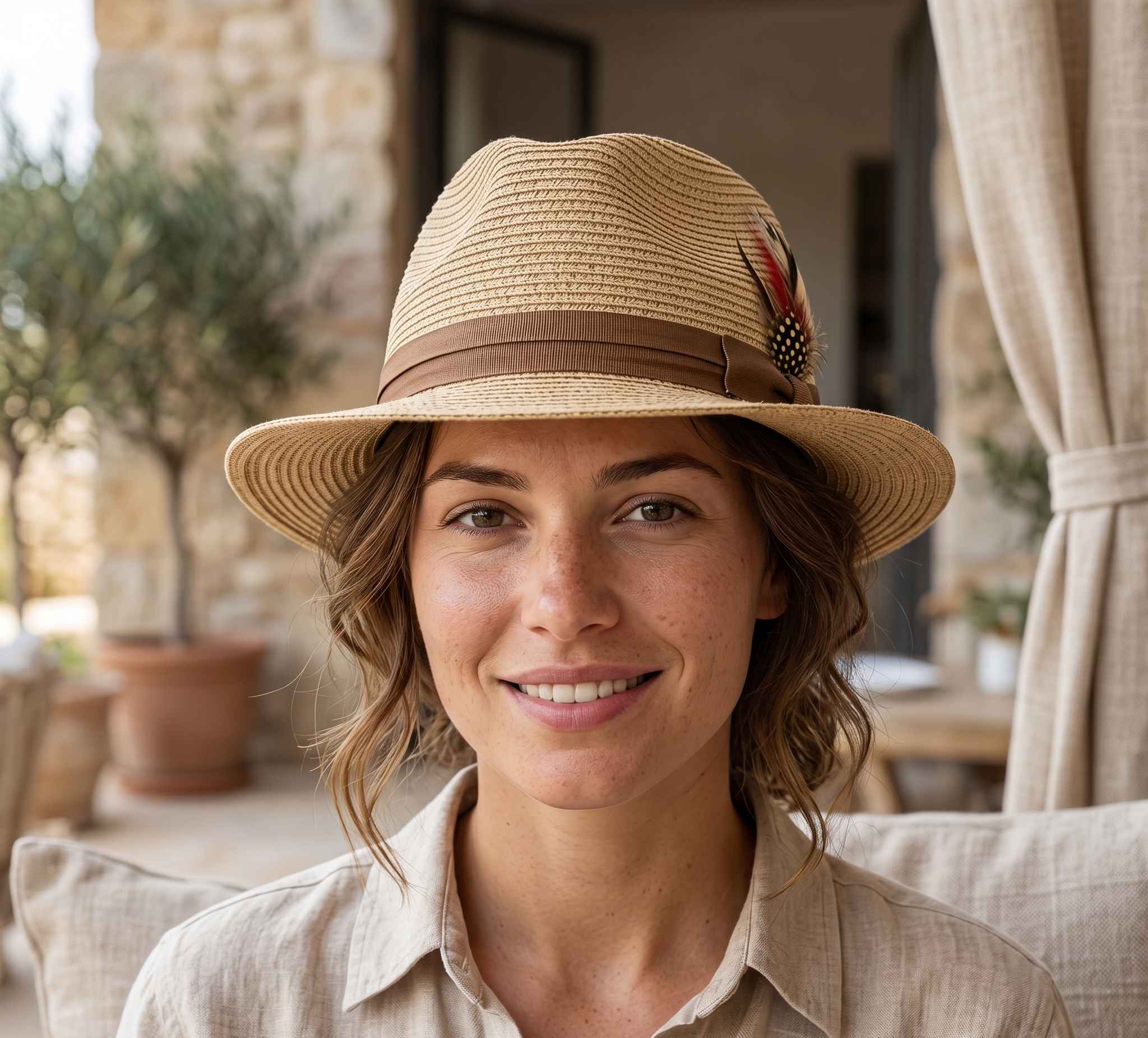 Woman wearing a straw hat with a brown band outdoors